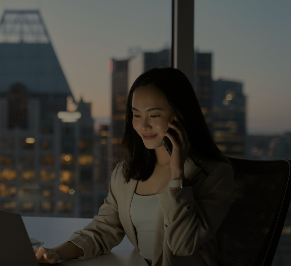 사람이 전화를 받으며 노트북을 보고있음